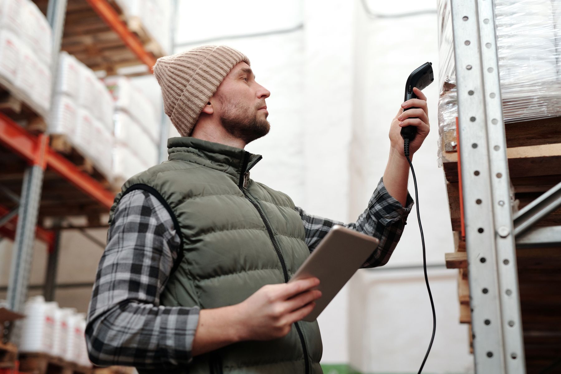 Warehouse employee scanning wrapped inventory with a handheld scanner